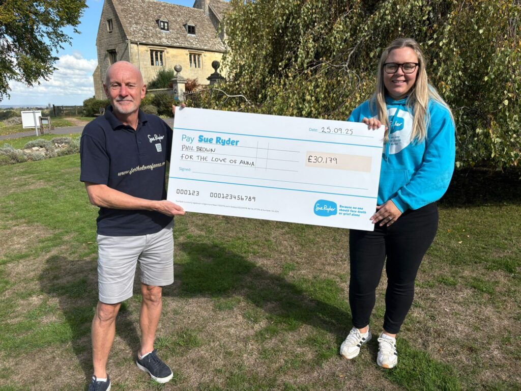 Laura Jeffries from Sue Ryder presents Phil Brown with his cheque