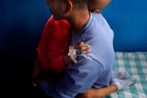 Photo credit: Narendra Shrestha, Two Worlds Cancer Collaboration, June 2022 . Udrisya Bista, aged 7, is comforted by his older brother during his treatment at the Pediatric Care Unit of Bhaktapur Cancer Hospital, Bhaktapur, Nepal. 